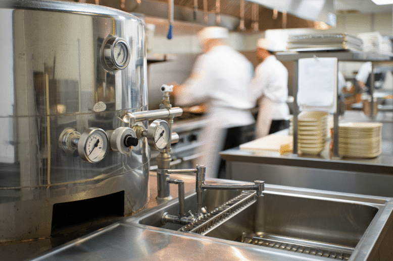 Industrial kitchen with stainless steel equipment and an integrated biodigester unit